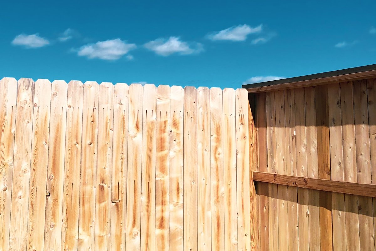Storm-damaged wood fence repair on a property line in Austin, Texas